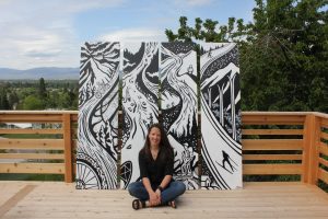 Image of woman sitting in front of four outdoor themed art pieces