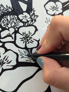 close up image of hand drawing detailed black and white flower on canvas