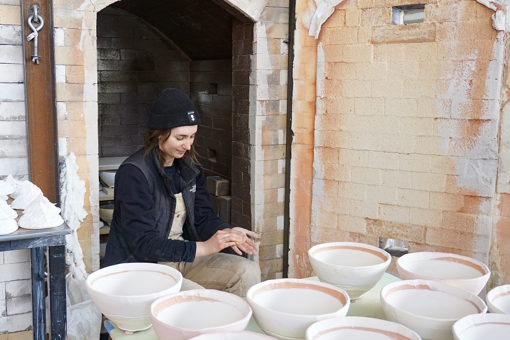 Artist with pottery in a kiln