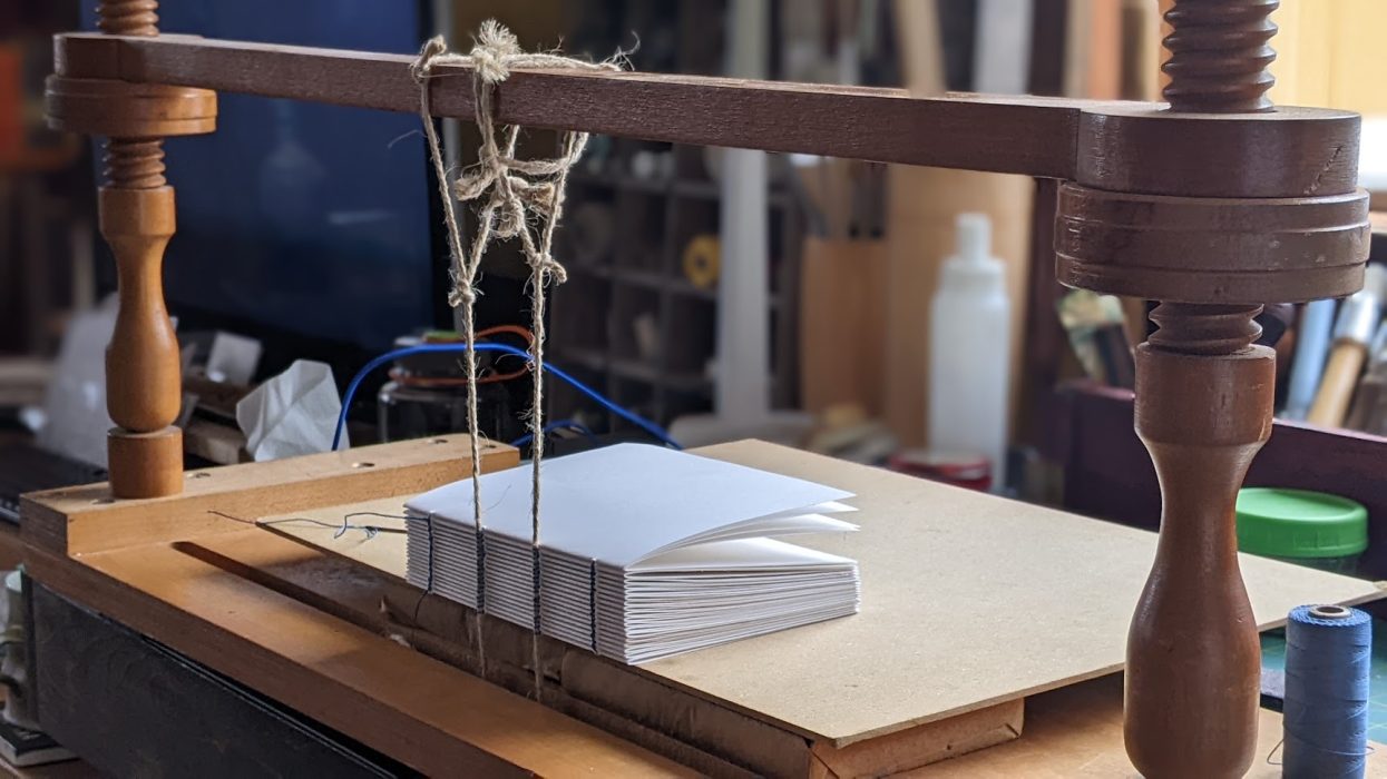 a book block being sewn on a frame