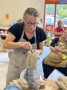 artist making a clay figure sculpture 