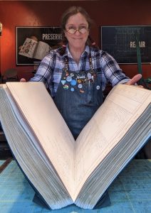 Audra Loyal presenting a giant ledger